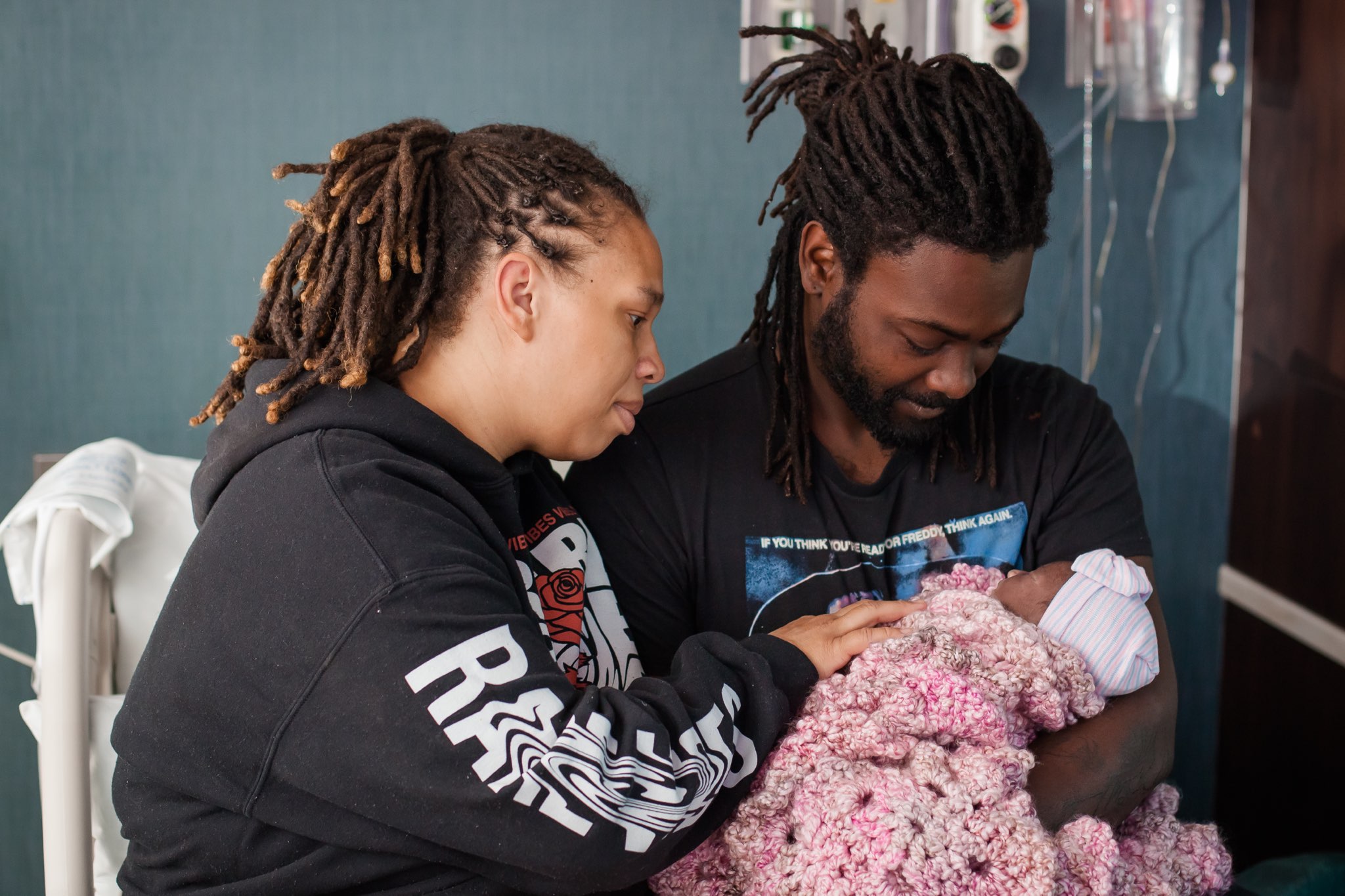 Ashley and Ivey’s dad in the hospital, gazing down at baby Ivey wrapped in a pink blanket