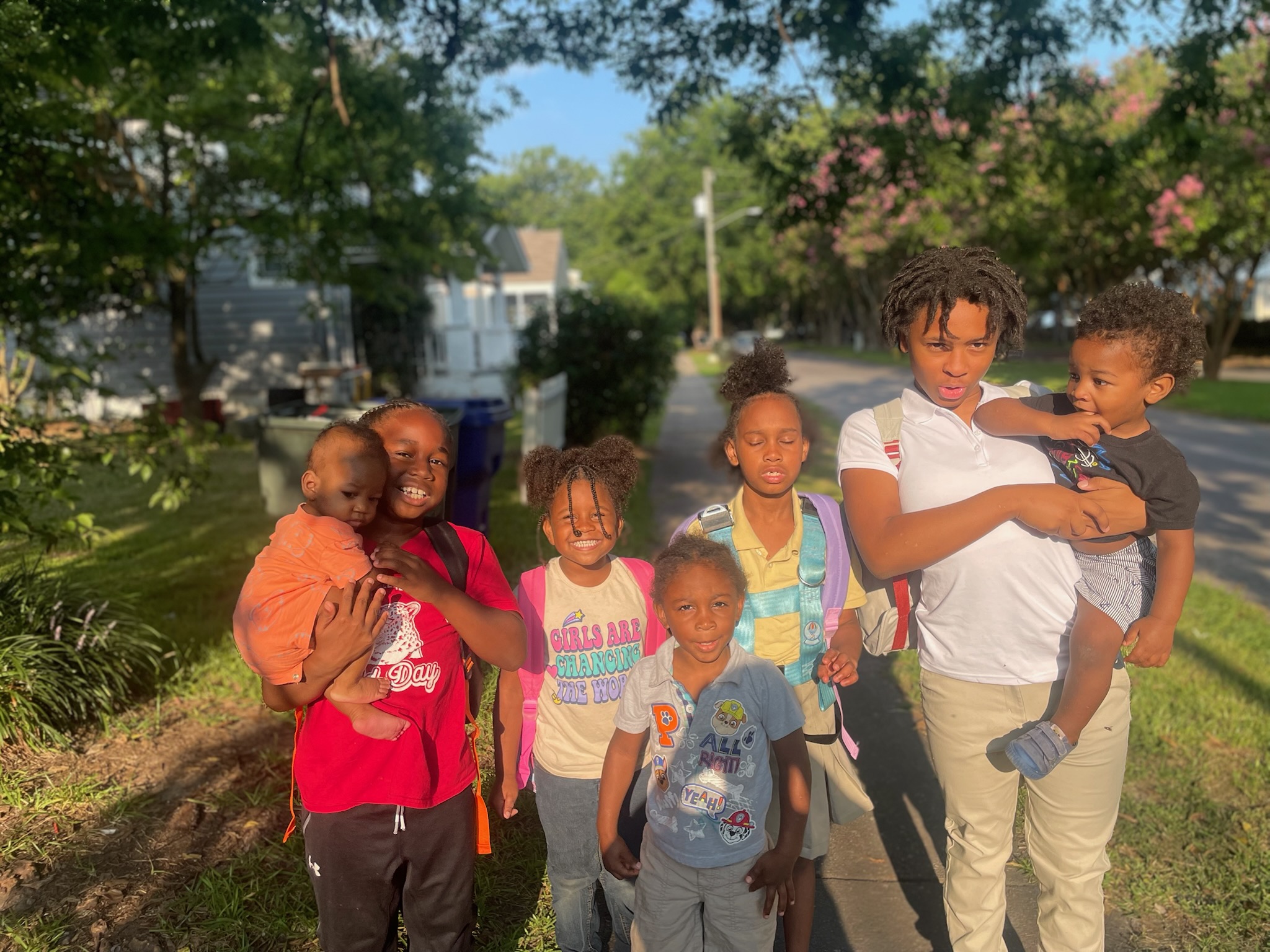 Ashley’s seven children gathered together on a sunny sidewalk — the crew behind the dessert bar